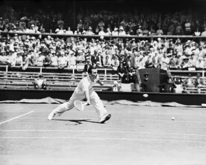 Fred Perry playing a low forehand shot at The Wimbledon Mens Tennis Championships 1935