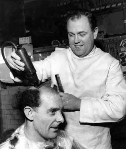 Hairdressers Prints: Fred Threlfall under way as barber Mr. Joseph Stafford starts with the electric clipper