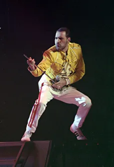Mercury Prints: Freddie Mercury of Queen on stage, performing an air guitar. November 1989