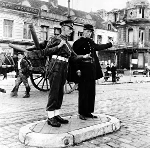 Matching Prints: French policeman talks to an army soldier in the centre of Calais France