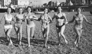 Friends ejoying the early spring sunshine on Brighton beach. Circa April 1952