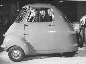 Motors Prints: Three friends sit in a three wheeler Scootacar at the Earls Court Cycle and Motorshow