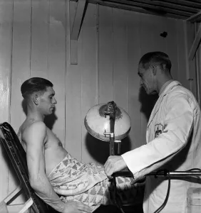 Physio Prints: Fulham F. C. Trainer F Penn treats Jimmy Taylor for injury. March 1949 O17597