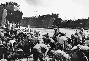 01459 Prints: While the gaping bow doors of amphibious assault craft spew forth more men and supplies