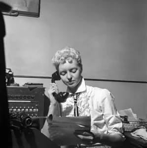 General office scene: Secretary taking notes and answering the phone in a Birmingham