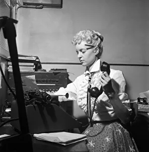 General office scene: Secretary taking notes and answering the phone in a Birmingham