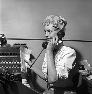 General office scene: Secretary taking notes and answering the phone in a Birmingham