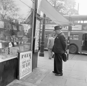 Briefcase Prints: Gentleman looking at local classified and personal adverts on notice board outside shop