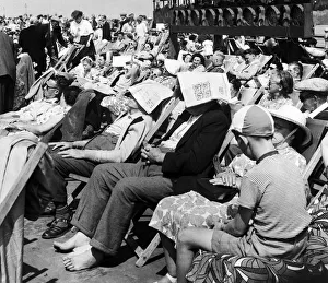 Two gentleman sitting on a busy Blackpool promenade in Lancashire