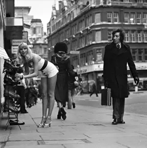 Admiration Prints: A gentlman admires model Christine Donnas behind as she searches out a new pair of
