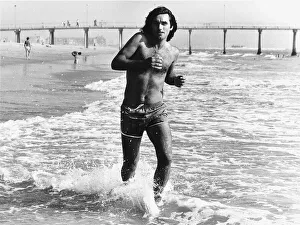 Shorts Prints: George Best football goes jogging on a beach in California