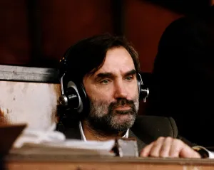 George Best former footballer wearing headphones commentating on a match for the radio