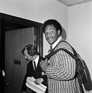 01524 Collection: George Foreman at Heathrow airport, wearing a striped jacket and carrying a shoulder bag