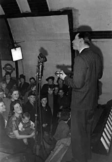 Tube Prints: George Formby taking part in variety entertainment at Aldwych tube station. November 1940
