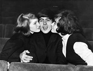 01227 Collection: George Harrison of The Beatles is kissed by two female fans