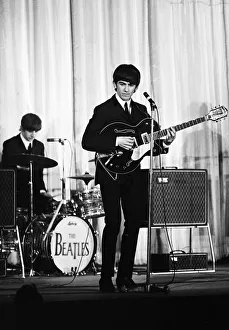 George Harrison of the Beatles performing on stage November 1964