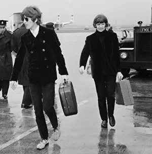 George Harrison and Ringo Starr leave a rainsoaked London Airport for Chicago via Boston
