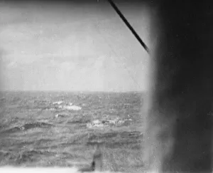 The German battleship Bismarck burns on the horizon approximately 350 miles west of