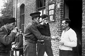 00492 Prints: On the German border, war correspondant Rex North buys a drink for the road at the last