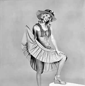 German glamour model Maureen wearing a short sleeved frilly dress and hat