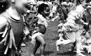 Toddler Prints: Getting carried away by the dancing at the Garston Carnival is two year old Felicia Zenko