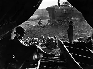 Caravans Prints: Gipsies in camp. View from inside a tent. A woman sits and thinks while a group of