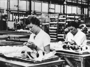 Balls Prints: Girls covering the black case of the tennis balls with felt at the Dunlop Works in
