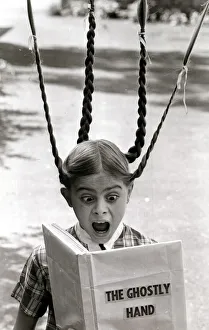 A girls pigtails stand on end in terror as she reads a scary ghost story