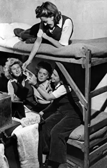 00071 Prints: Girls of the Womens land Army looking at photographs in the sleeping quarters of
