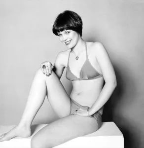 A glamour model posing wearing bikini and various items of jewellery including rings