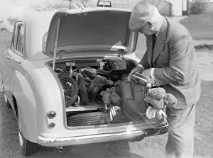 Golfer seen here storing his golf clubs in the boot of his brand new Standard 8 car Circa