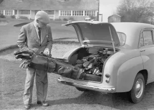 00573 Prints: Golfer seen here storing his golf clubs in the boot of his brand new Standard 8 car Circa
