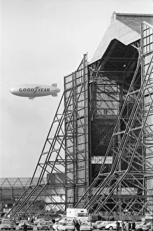 Advertising Prints: The Goodyear airship Europa seen here flying past the giant R101 sheds at Cardington