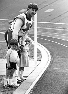 Knowsley Prints: Green Cross Code man Dave Prowse gives some local youngsters a hand crossing the track