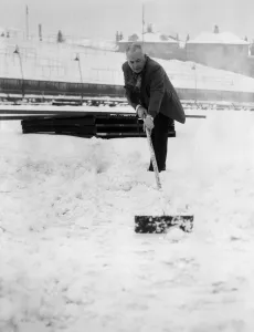 Grounds staff at Bristol Rovers Eastville Stadium struggle to clear snow from the pitch