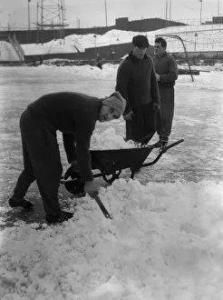 Grounds staff at Bristol Rovers Eastville Stadium struggle to clear snow from the pitch