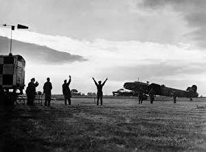 00189 Prints: The group captain commanding officer of an RAF station signals a Halifax bomber to begin
