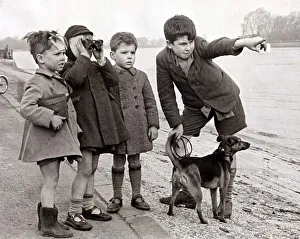 Directions Prints: A group of children look to the distance using a pair of binoculars