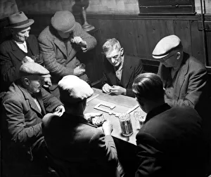 A group of elderly men taking their game of pub dominoes very seriously. Circa 1947