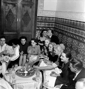 A group of friends gathered around a table enjoying drinks on a night out in Marrakech