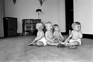 A group of young babies seen here getting into a mess with a chocolate cake at a babies