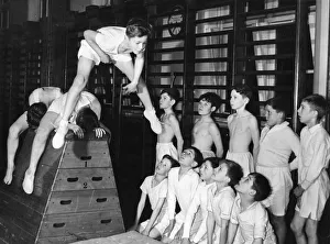 Fitness Prints: A group of youngsters watch as Richard McKenzie does a astride vault in the gymnasium