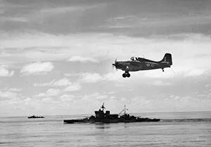 01442 Prints: A Grumman-Martlett of the Royal Navy Fleet Air Arm flying over the battleship HMS