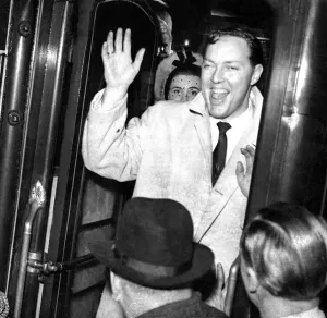 Bill Haley and his Comets wave goodbye to fans as he boards a train March 1957