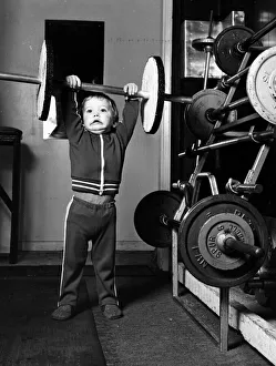 Strength Prints: Two and half year old boy Ian Page lifts a set odf special wooden weights built for him