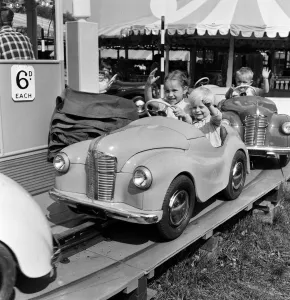 Fairground Prints: Hampstead Heath Fair, London. Jane and Peter Hindley of Highgate on a motor roundabout