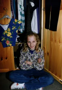 Hannah Walton on of the Walton Sextuplets sits cross legged in front of her open wardobe