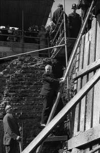 Harold Wilson climbs a builders ladder during a visit to Toynbee Hall in the procsess