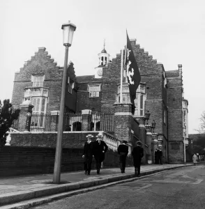 00089 Prints: harrow schoolboys wearing their school uniform pass by the side of the college