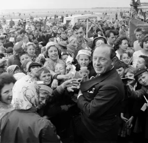 Harry Corbett and Sooty mobbed by fans at the Daily Mirror Beach party. August 1958